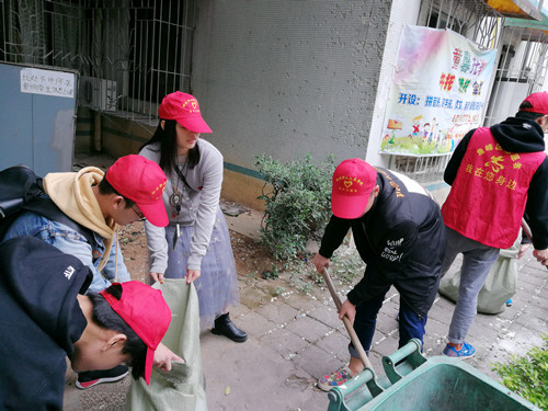 志愿者在清理小区花圃里的垃圾