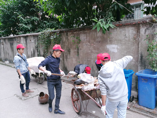 志愿者在清理小区居民堆放的建筑垃圾